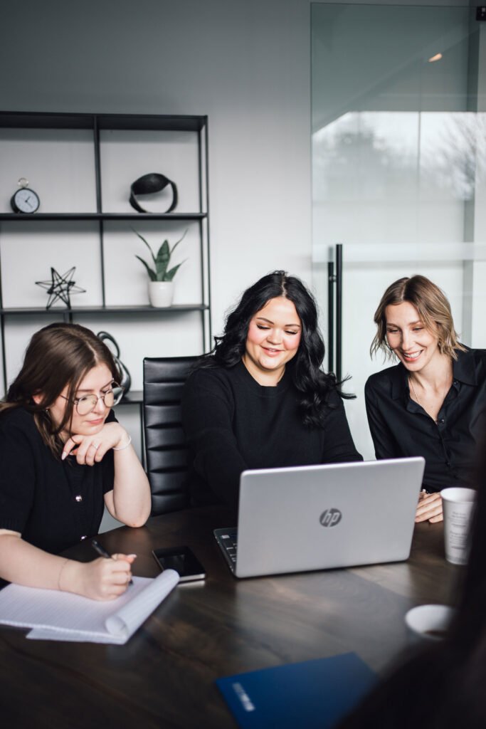 Three people smiling during a meeting at a table
