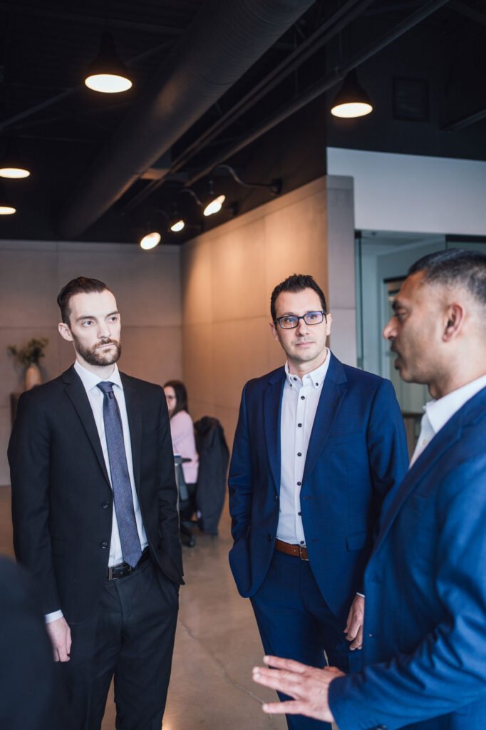 Three business people stand in an office talking