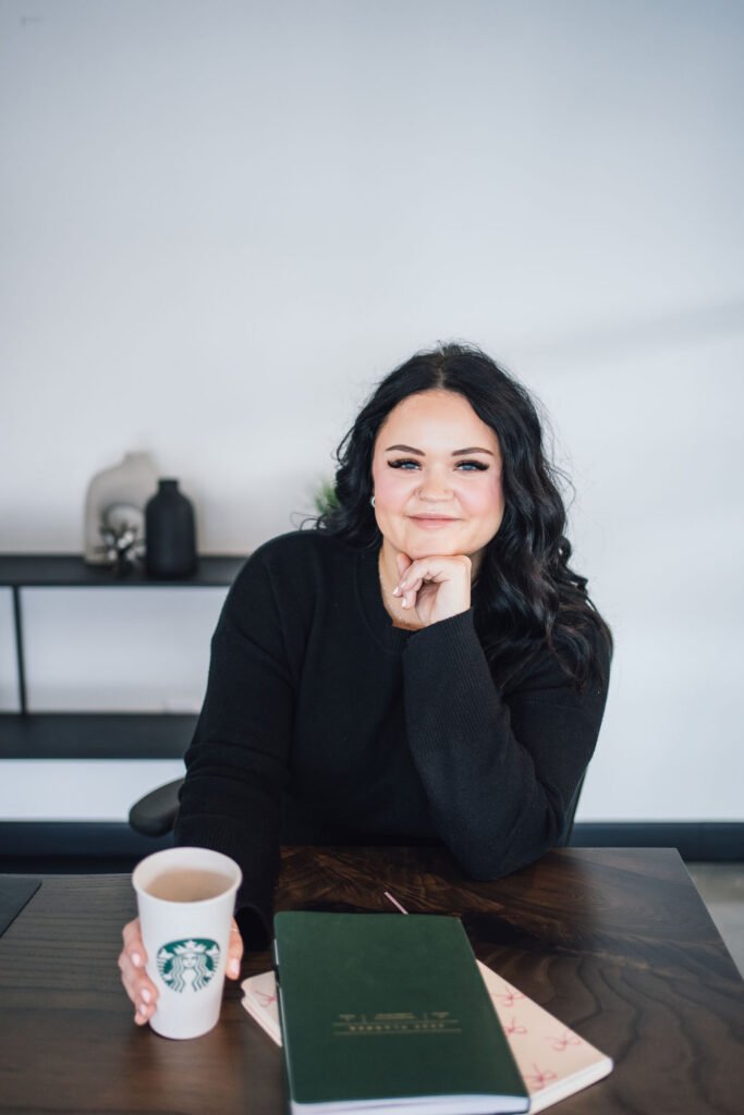 A buisness person sitting with a coffee at a desk
